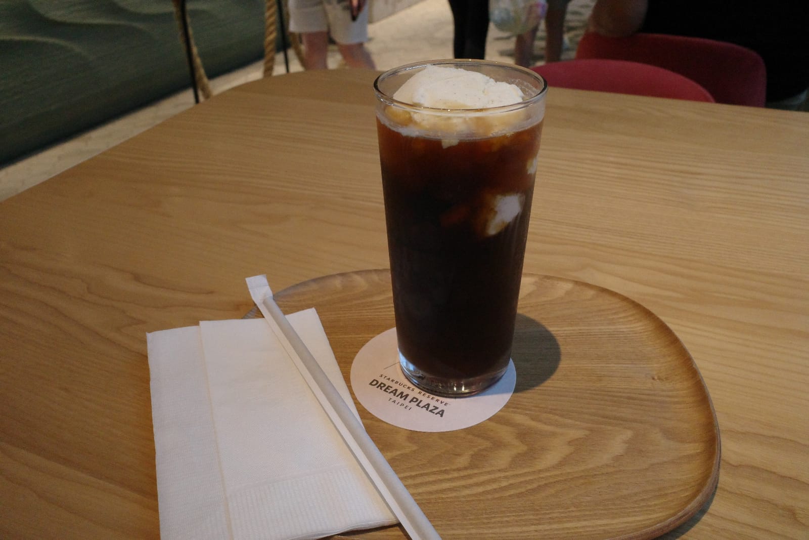 コーヒーフロート。深煎りアイスコーヒーにバニラアイスが浮かび、コースターには DREAM PLAZA TAIPEI のロゴ