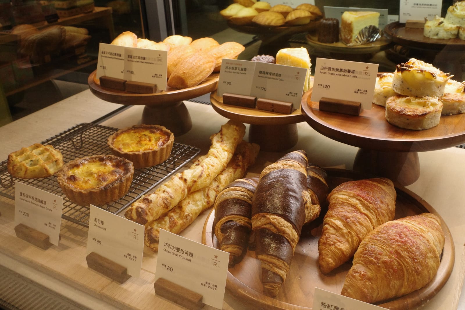 ペストリーケースに並ぶ Bacon Quiche、Cheese Stick、Choco Bicolor Croissant、Potato Gratin with White Truffle の値札